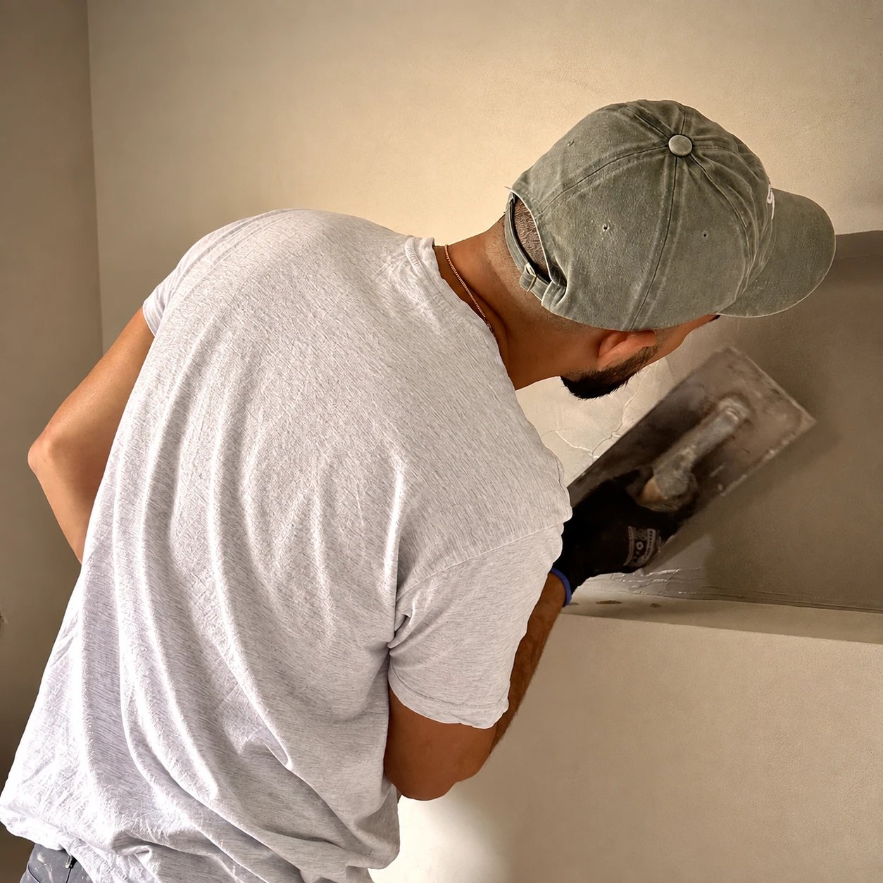 Vakman brengt microcement aan op een wand